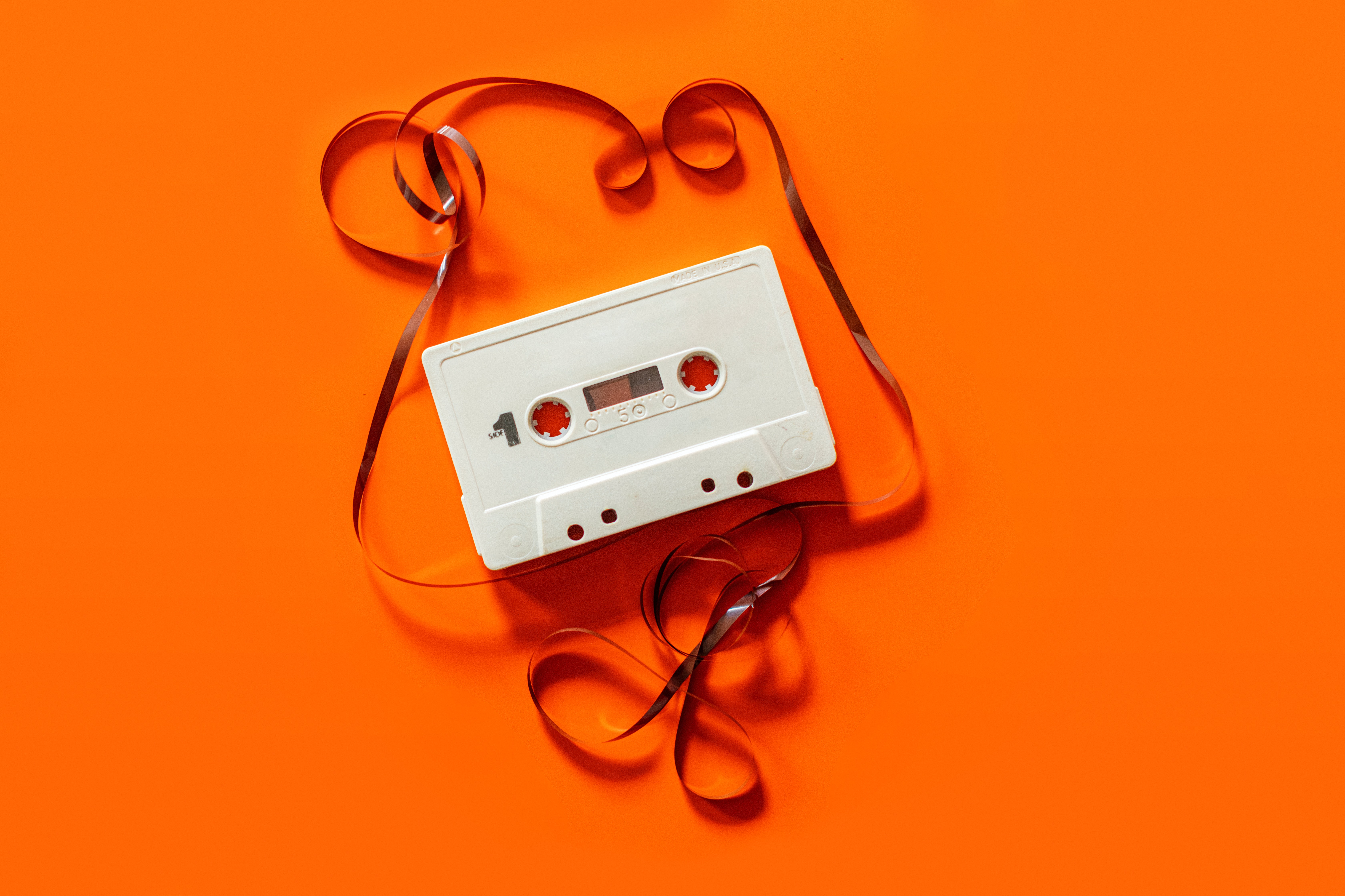 a white casette tape on a bright orange background
